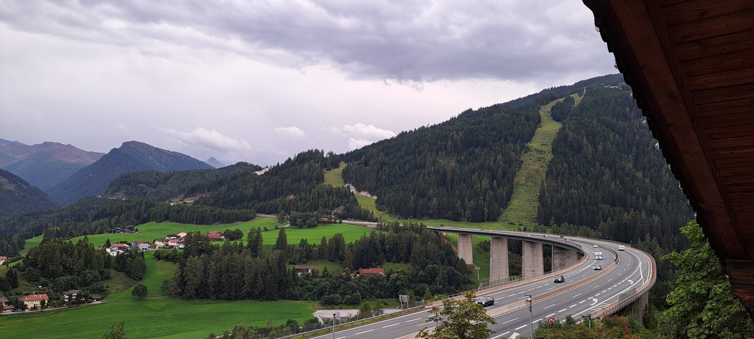 Assisi 2025 Wipptalerhof mit Autobahnbrücke Blick vom Wipptalerhof richtung Brenner. Autobahnbrücke und Wolkenverhangene Berge.