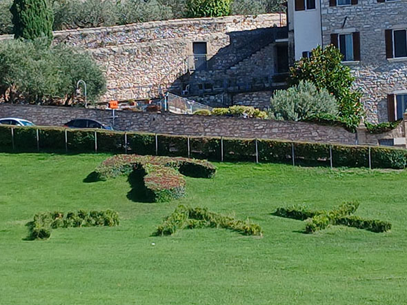 20250918_153915 Tau-Kreuz und PAX-Schriftzug auf einer Wiese vor San Francesco
