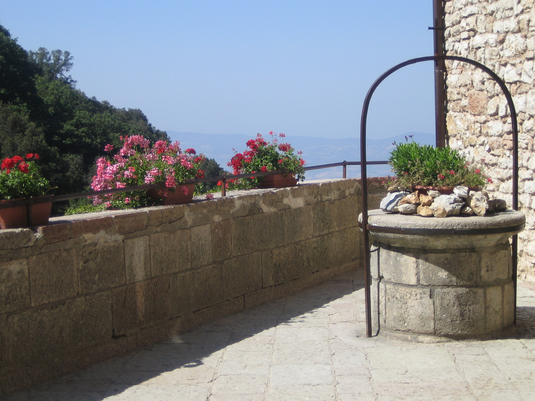 Carceri (5) Mauer und Brunnen mit Blumenkübeln vor blauem Himmel