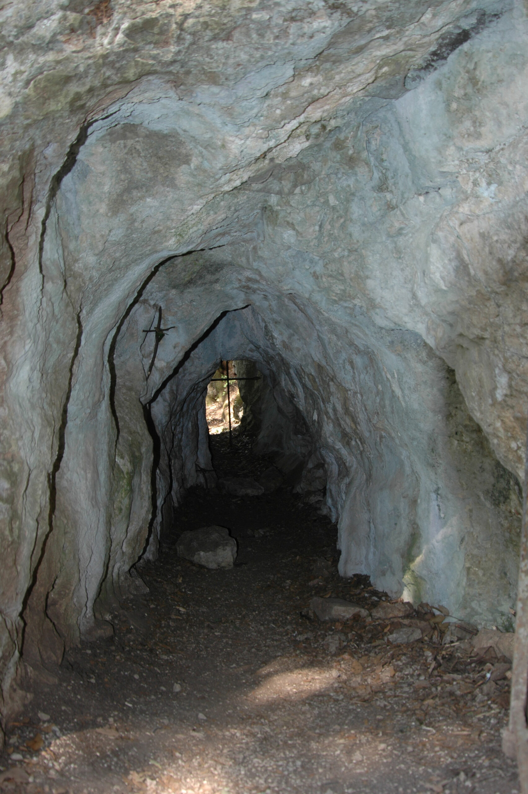 Carceri (50) Eine Höhle aus weißem Fels, am Ende der Höhle ist Licht sichtbar