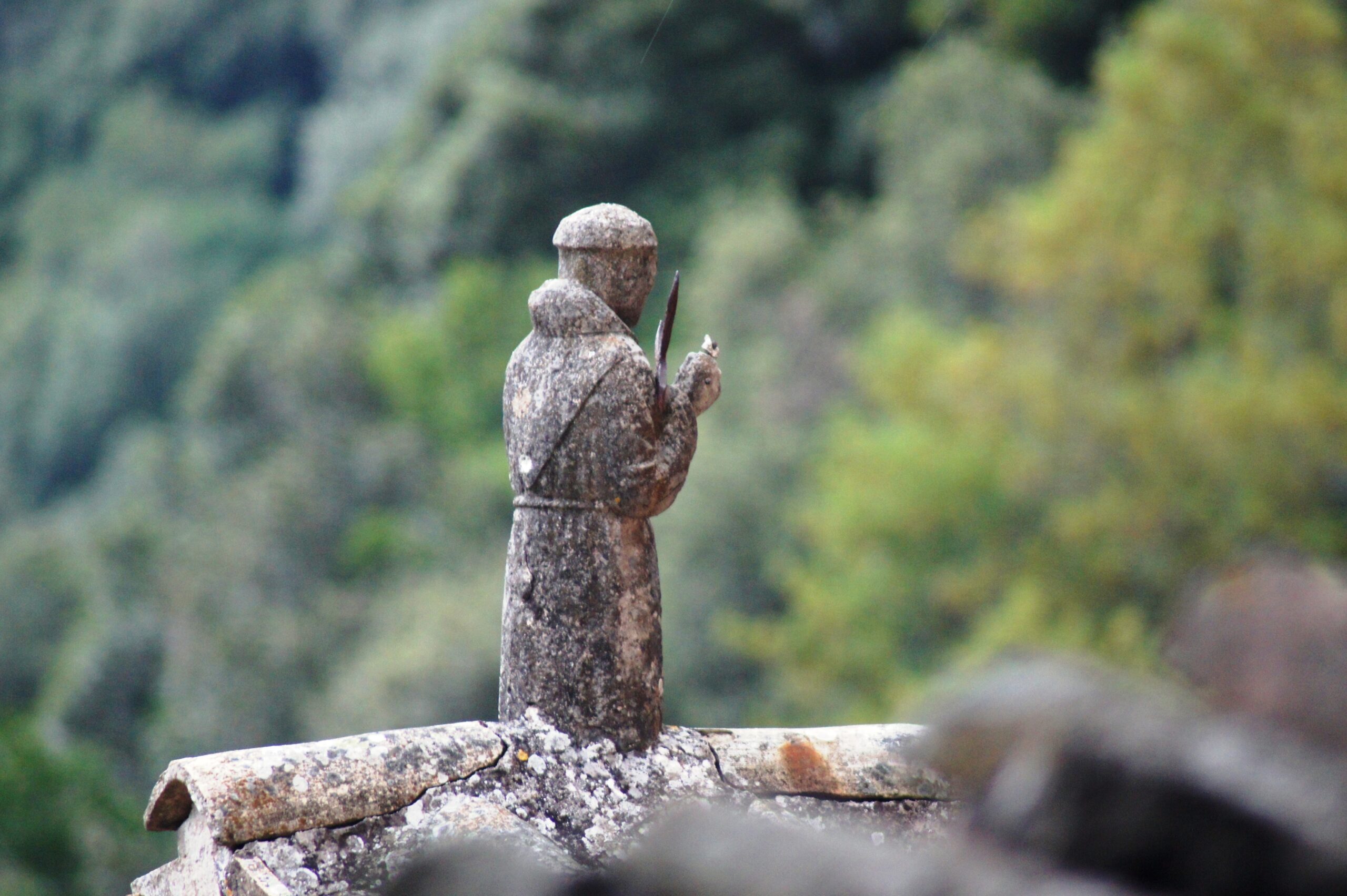 Carceri 1 Eine Kleine Statue des hl. Franziskus auf dachzeigeln stehend.