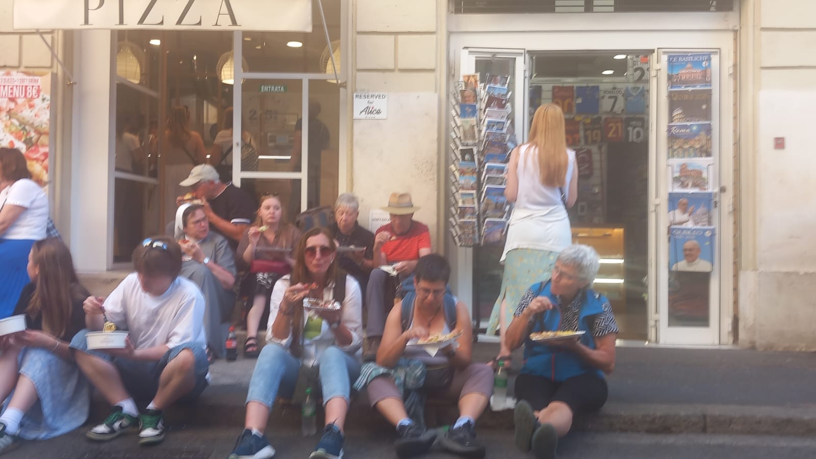 Personen beim Essen vor eiem Gebäude