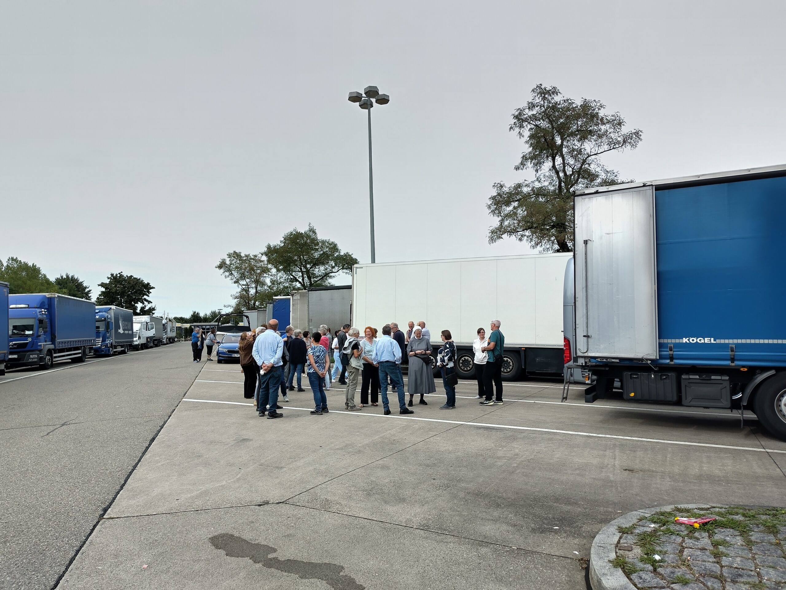Assisi 2025 Rastplatz Eine Personengruppe auf einem Rastplatz zwischen LKWs