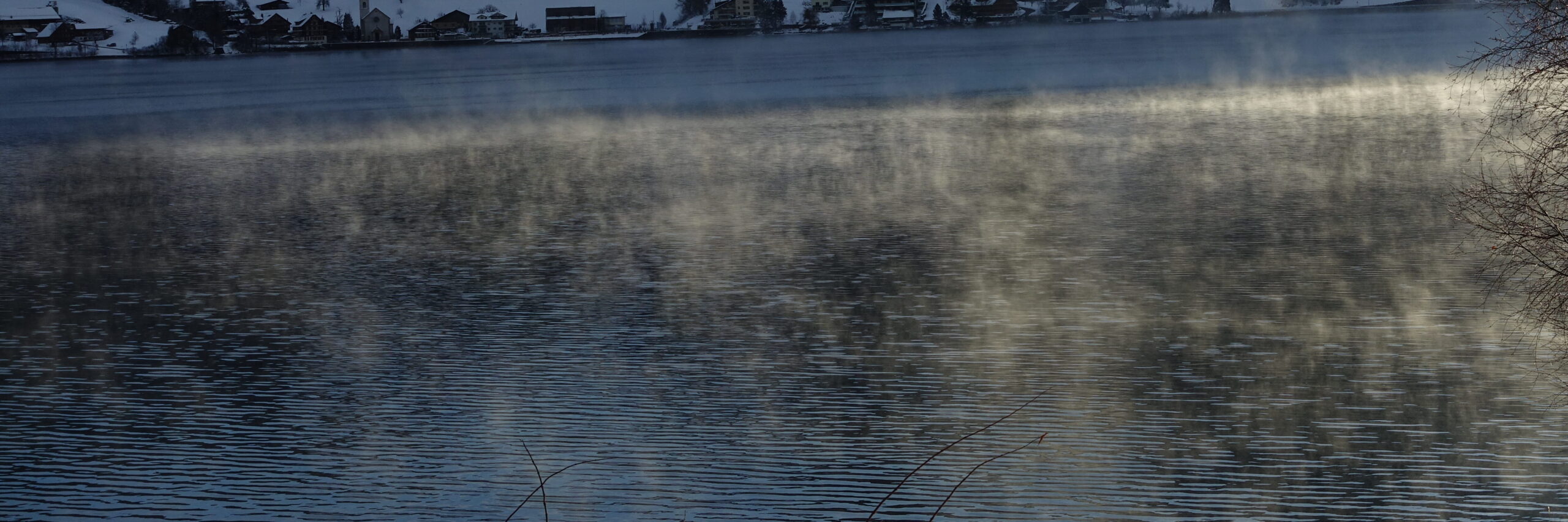 Wasser aus dem Nebelschwaden aufsteigt, die in der Sonne leuchten